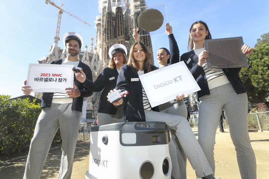 MWC 2023에 참가하는 KT 모델들이 AI 반도체, 배송로봇 등 전시 물품을 들고 홍보하고 있다.  KT 제공